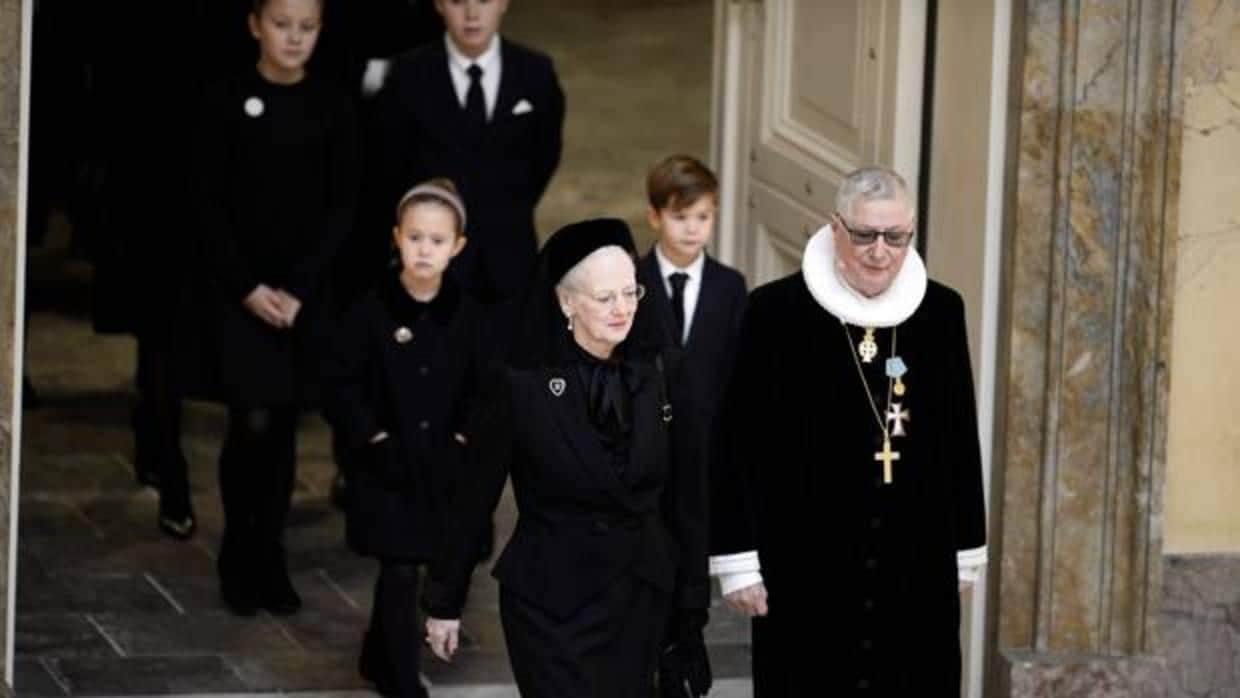 La Reina Margarita II, acompañada por el confesor real, Erik Norman Svendsen, y sus nietos (detrás), en el funeral del Príncipe Enrique