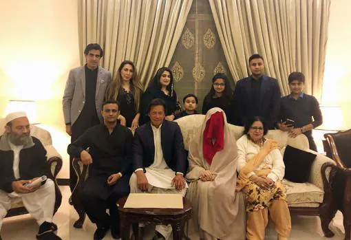 Khan, de blanco, junto a su esposa, con velo integral