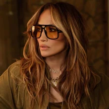 Jennifer Lopez con mechas money piece hair, iluminando su melena castaña.