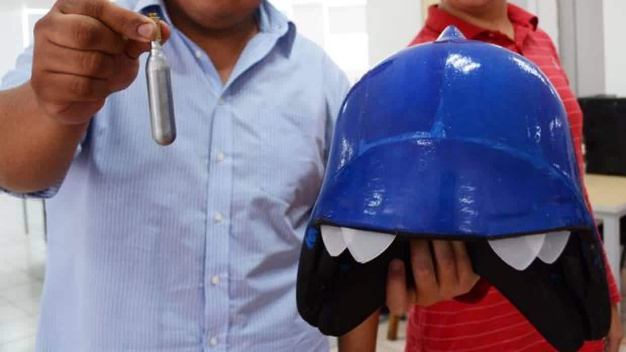 Dos investigadores muestran el casco para eliminar piojos