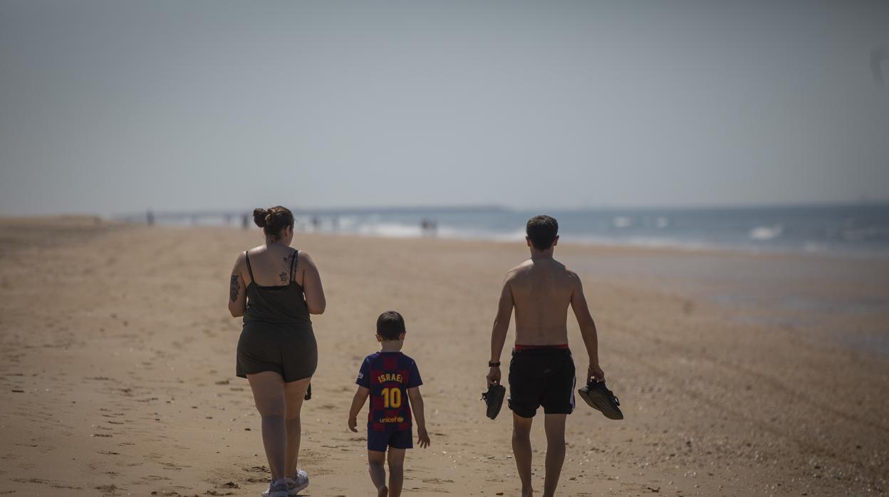 Una familia pasea por la Playa de Punta Umbría