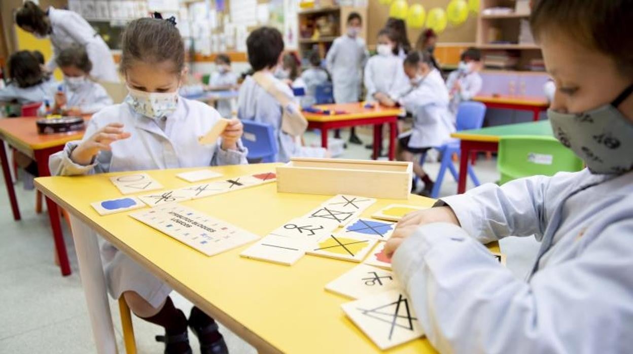 Dos alumnas practican en el aula con fichas para asimilar el aprendizaje de forma práctica
