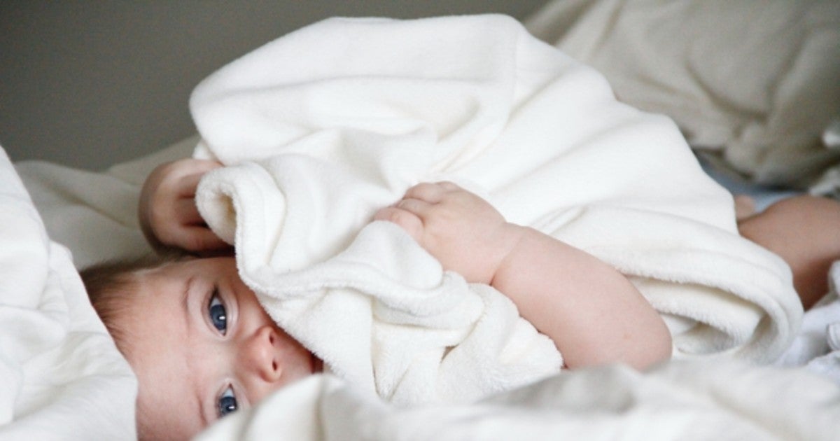 Bebé tapándose con una manta