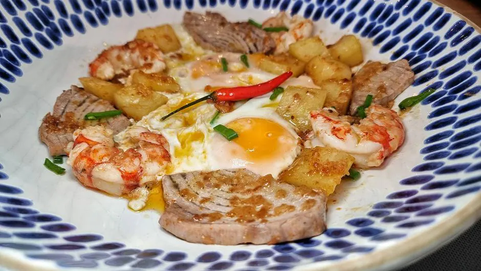 Salteado de alcachofas, marrajo, langostinos, huevos y jamón, uno de los platos de Doña Calma