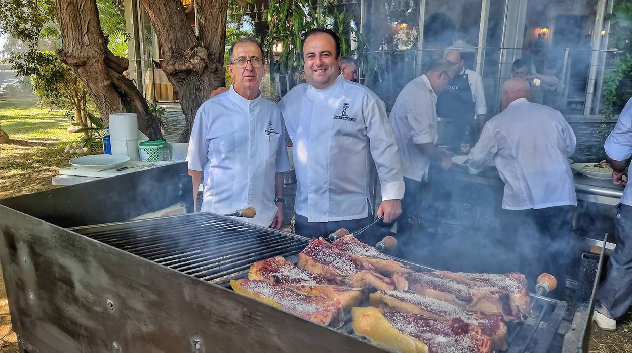 Fernando Córdoba e Iñaki Larrainzar, junto a la parrilla repleta de txuletas