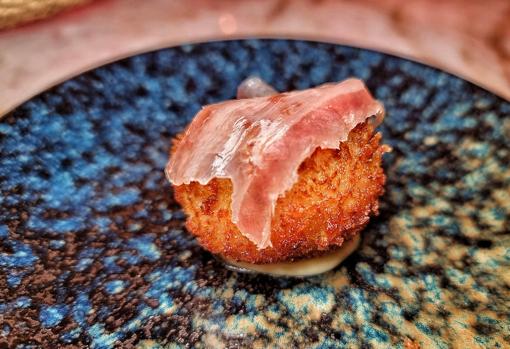 Croqueta de jamón ibérico con emulsión de su salsa y velo ibérico