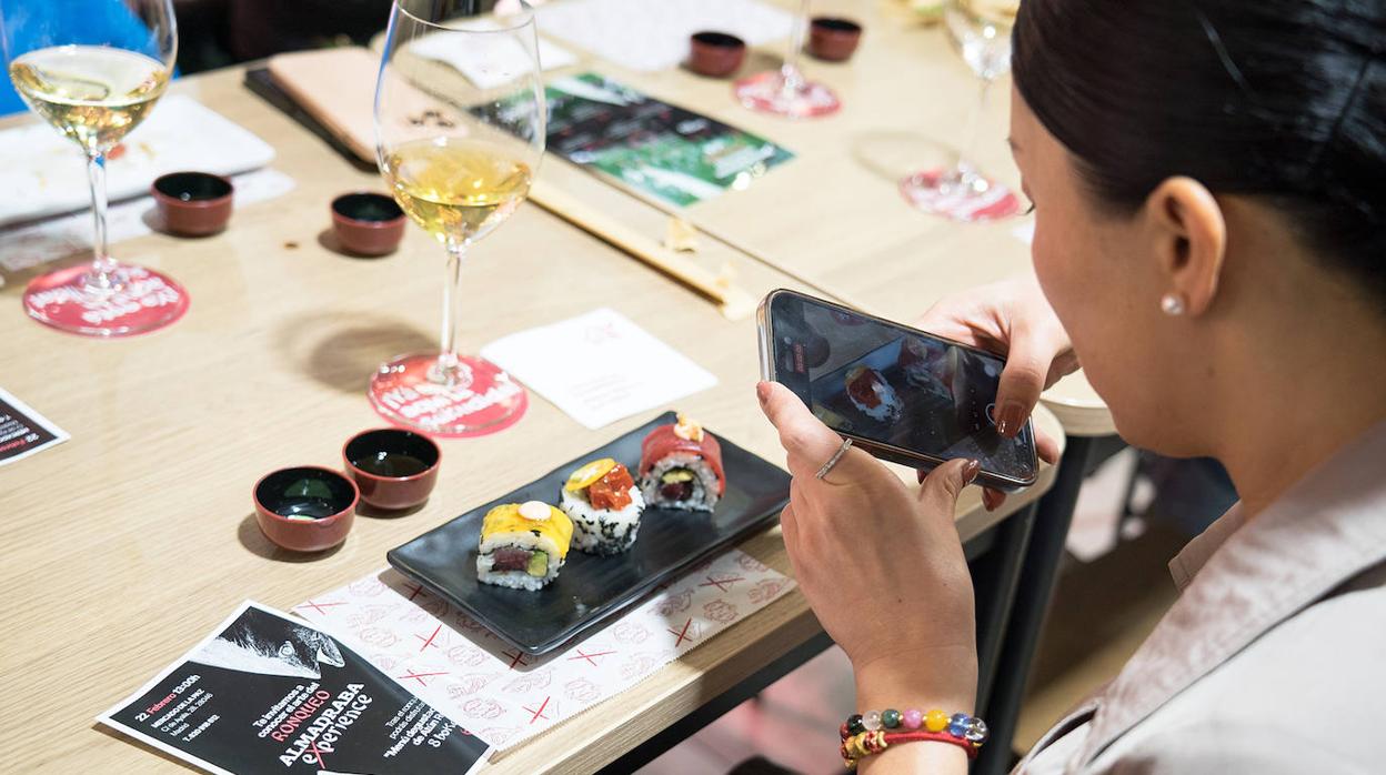 Una asistente al ronqueo, fotografiando uno de los platos del menú