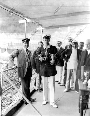 S. M. don Alfonso Xiii en la terraza del club náutico con las Copas que ha...