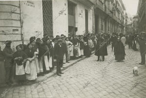 El público formando cola a la puerta de una panadería de la calle de Santa...