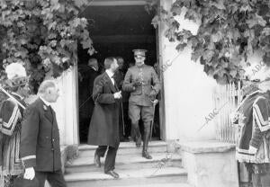 Don Alfonso Xiii, al salir del edificio Escuela, acompañado del director de la...