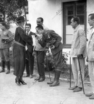 S.M. la Reina Hablando con los Oficiales Heridos, durante su Vistia al...