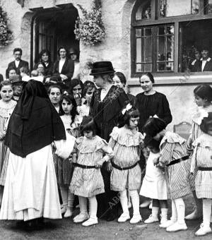 S.M. la Reina doña María Cristina (X), Rodeada de Varias Cieguecitas Asiladas,...