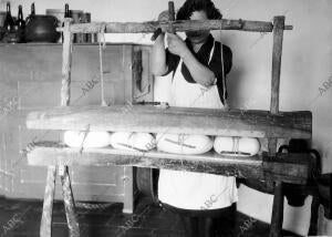 Preparación artesanal de queso en una queseria de los años 30