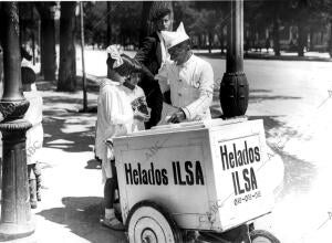 Un vendedor callejero de helados atendiendo a unas niñas