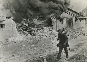 Entre ruinas humeantes que casi borran el trazado de las calles, la Infantería...