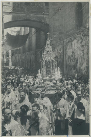 La custodia pasa bajo el arco de palacio, junto a los muros de la Catedral,...