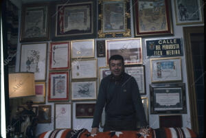 En la imagen junto a la pared en la que están colgados numerosos diplomas y la...