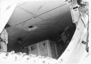 Un grupo de operarios saca de la bodega del avión las cajas que contienen el...