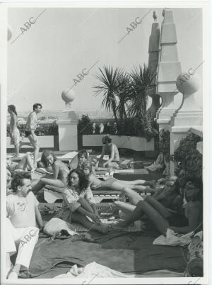 Personas tomando el sol en la piscina de la terraza del Edificio España