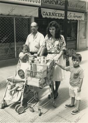 Un matrimonio con sus hijos tras hacer la compra