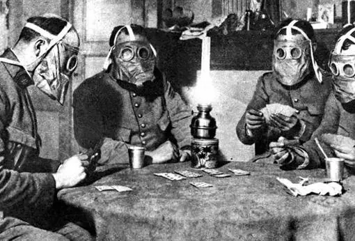En previsión de un ataque «químico», estos soldados juegan a las cartas cubiertos con una máscara antigás