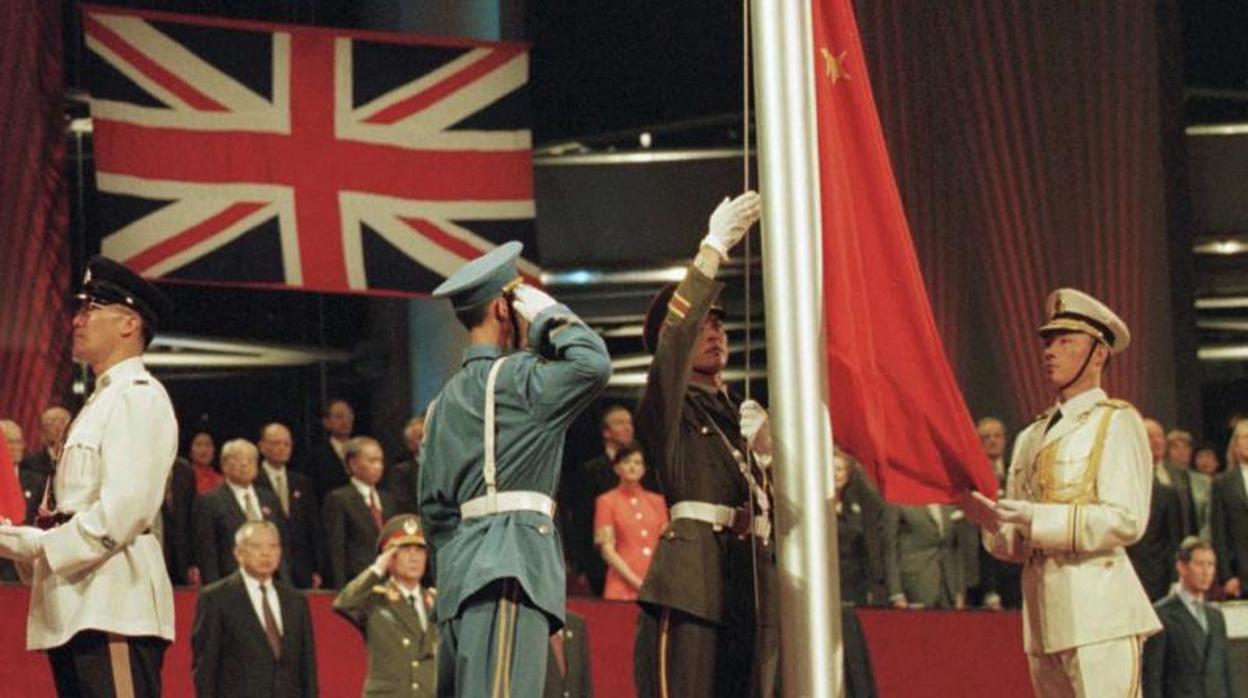 Miembros de las Fuerzas Armadas Chinas izan, en 1997, la bandera china en el centro de convenciones de Hong Kong.