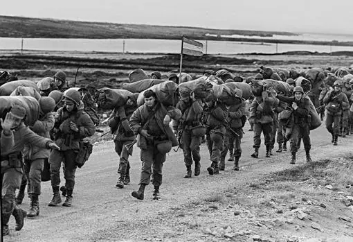 Soldados argentinos caminan el 13 de abril de 1982 para ocupar la base de los Marines Reales capturados en Puerto Argentino