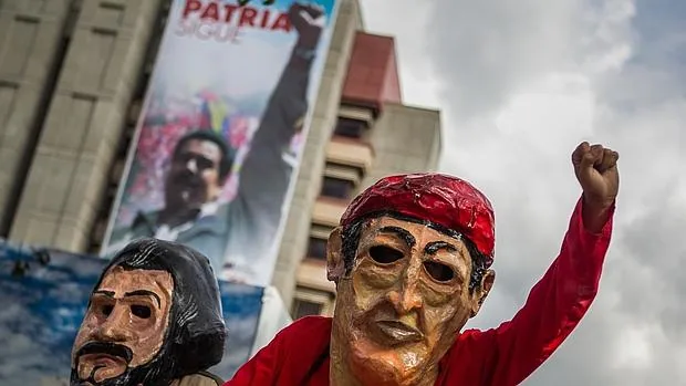 Seguidores de los candidatos del Partido Socialista Unido de Venezuela (Psuv) acuden a un acto de cierre de campaña de las municipales de diciembre de 2013 con máscaras de Ernesto Che Guevara (i) y Hugo Chávez