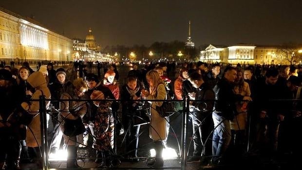 Varias personas dejan velas y flores para recordar a las víctimas del avión en San Petesburgo