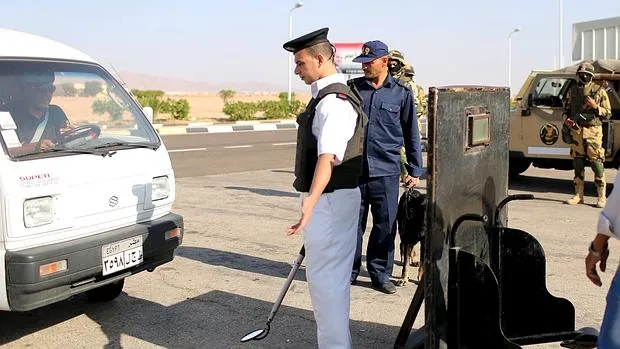 Un policía egipcio registra un vehículo en el acceso al aeropuerto