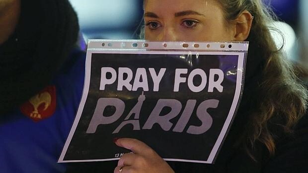Una joven sostiene un cartel de apoyo a las víctimas de los atentados en París