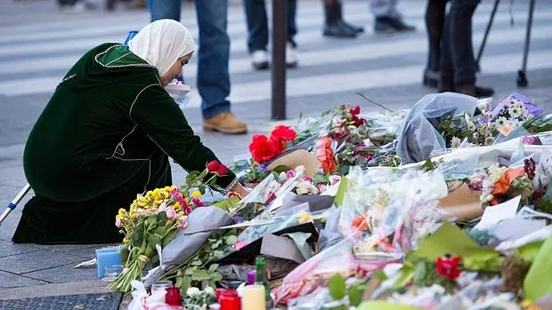 Una mujer deja una flor en recuerdo de las víctimas de los atentados