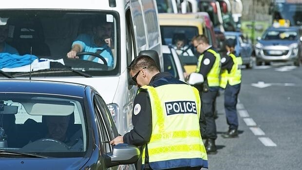 Agentes de la Policía francesa y española revisan la documentación de los vehículos en uno de los controles establecidos por efectivos en el municipio de Le Perthus (Francia)