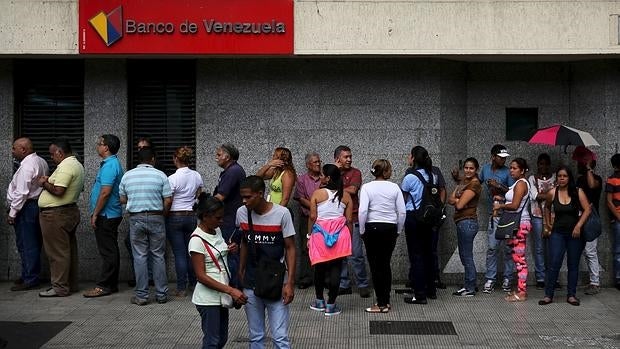 Cola de venezolanos junto a un cajero automático, este viernes en Caracas