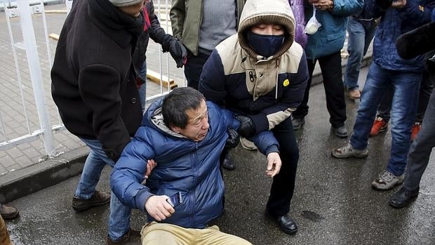 Uno de los manifestantes, en el suelo, mientras le intentan obligar a levantarse