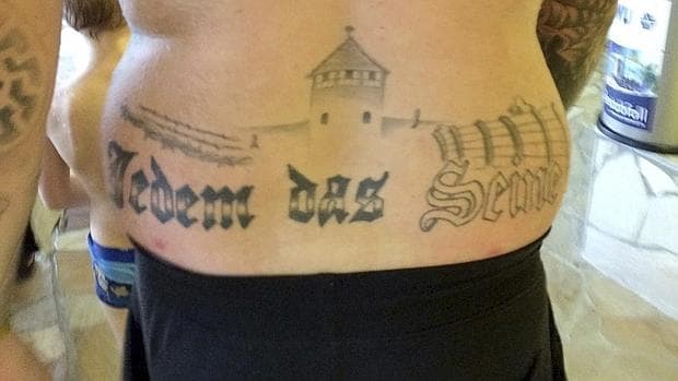 Tatuaje exhibido en una piscina pública de Oranienburg (Alemania), en una imagen colgada en Facebook, en la que se ve el edificio principal de Auschwitz y la frase «Jedem das Seine» ( a cada uno lo suyo)