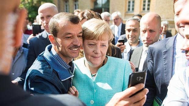 Un demandante de asilo se hace un «selfie» con Merkel en Berlín el pasado septiembre