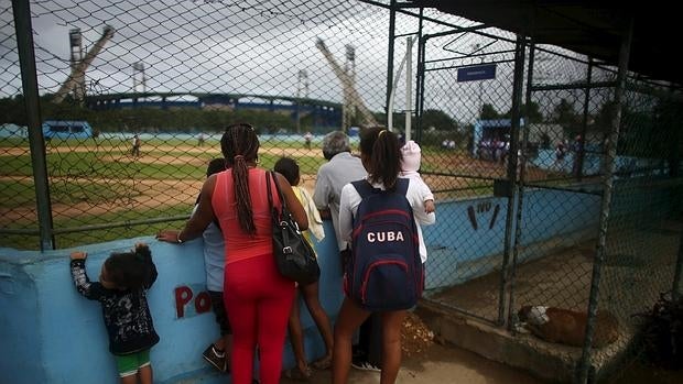 Cubanos presencian un partido de béisbol en La Habana