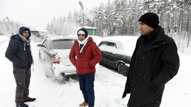 Un refugiado afgano (i) y un paquistaní (d) esperan cerca de la localidad rusa de Kuoloyarvi a poder cruzar la frontera con Finlandia