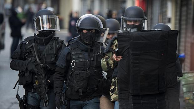 Miembros de la policía evacuando a un sospechoso (c) durante el asalto en Saint Denis, cerca de París