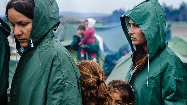 Mujeres y niñas esperan el reparto de comida en el campo de refugiados de Idomeni, Grecia