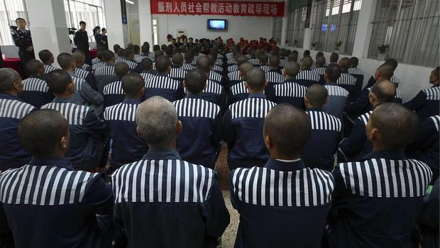 Un grupo de presos chinos ve la televisión