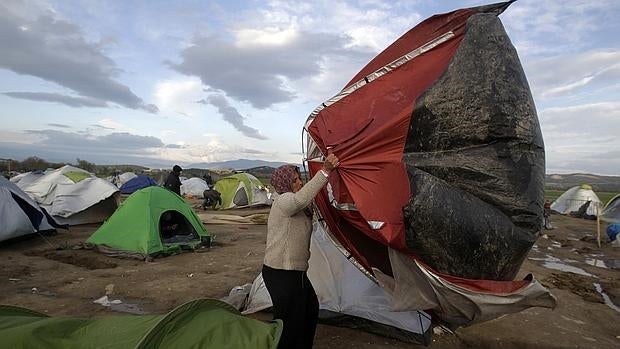 Una refugiada en el campamento griego de Idomeni trata de luchar con el viento