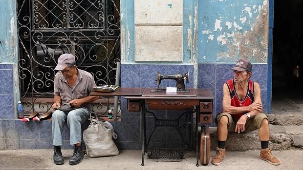 El congreso del partido no cambia la vida diaria de los cubanos. Unos habaneros reparan calzados o venden máquinas de coser en plena calle