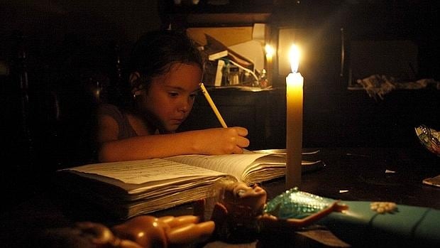 Una niña hace los deberes a la luz de una vela en San Cristóbal, estado Táchira