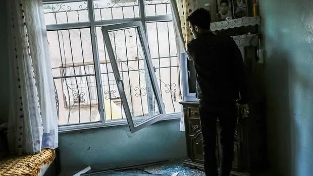 Un hombre mira por la ventana de su casa destrozada en Kilis (frontera turca), tras las bombas lanzadas el pasado día 24 desde una zona de Siria controlada por Daesh