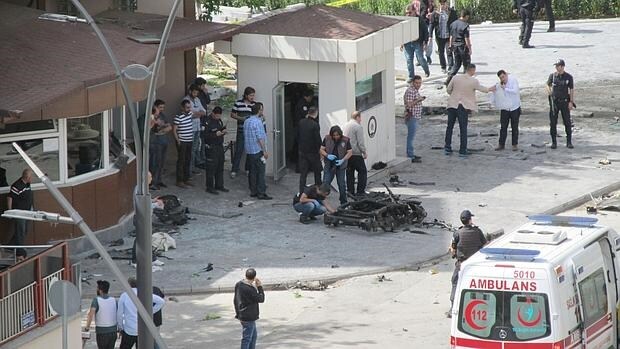 Policías inspeccionan la escena después de la explosión frente al cuartel general