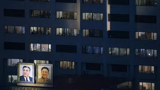 Retratos de los desaparecidos líderes de Corea del Norte, Kim Il-Sung (i) y Kim Jong-Il (d), exhibidos en un moderno edificio de Pyongyang en vísperas del congreso del partido único
