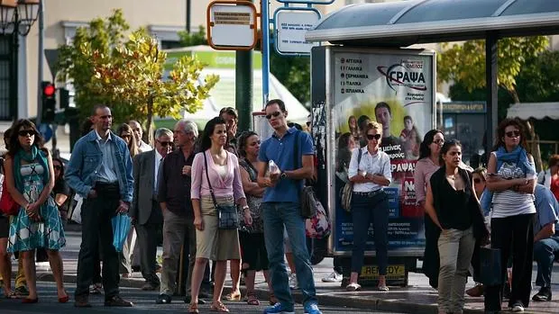 Pasajeros esperan la llegada de un autobús, durante una huelga de 2011 en Atenas