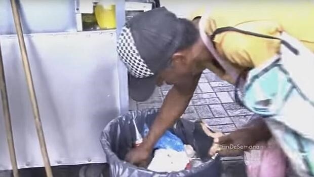 Un venezolano busca comida en la basura